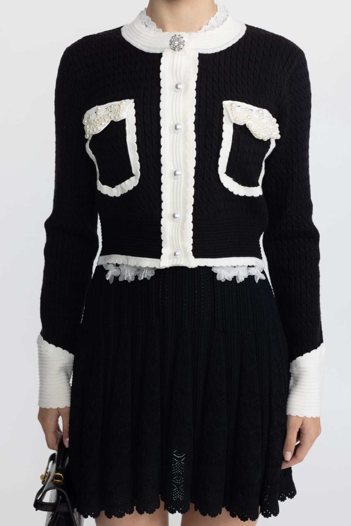 Kurze Cable-Strickjacke mit Perlenbesatz und Kontrastkante - Schwarz