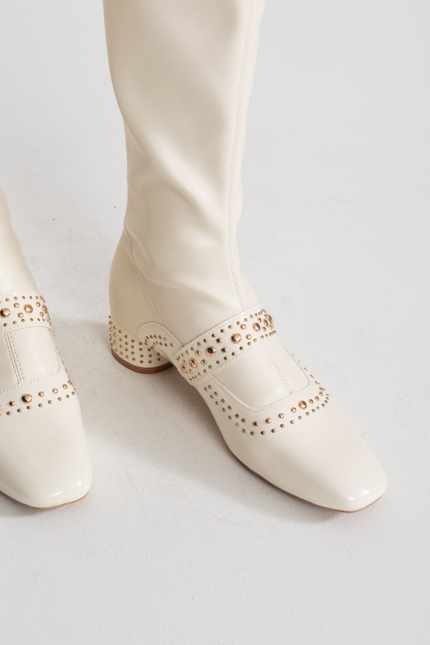 Nietenbesetzte kniehohe Stiefel mit Perlenriemendetail – Ivoire