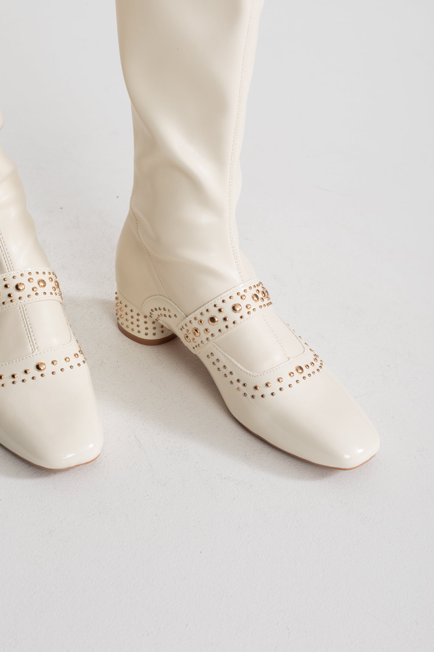 Nietenbesetzte kniehohe Stiefel mit Perlenriemendetail – Ivoire