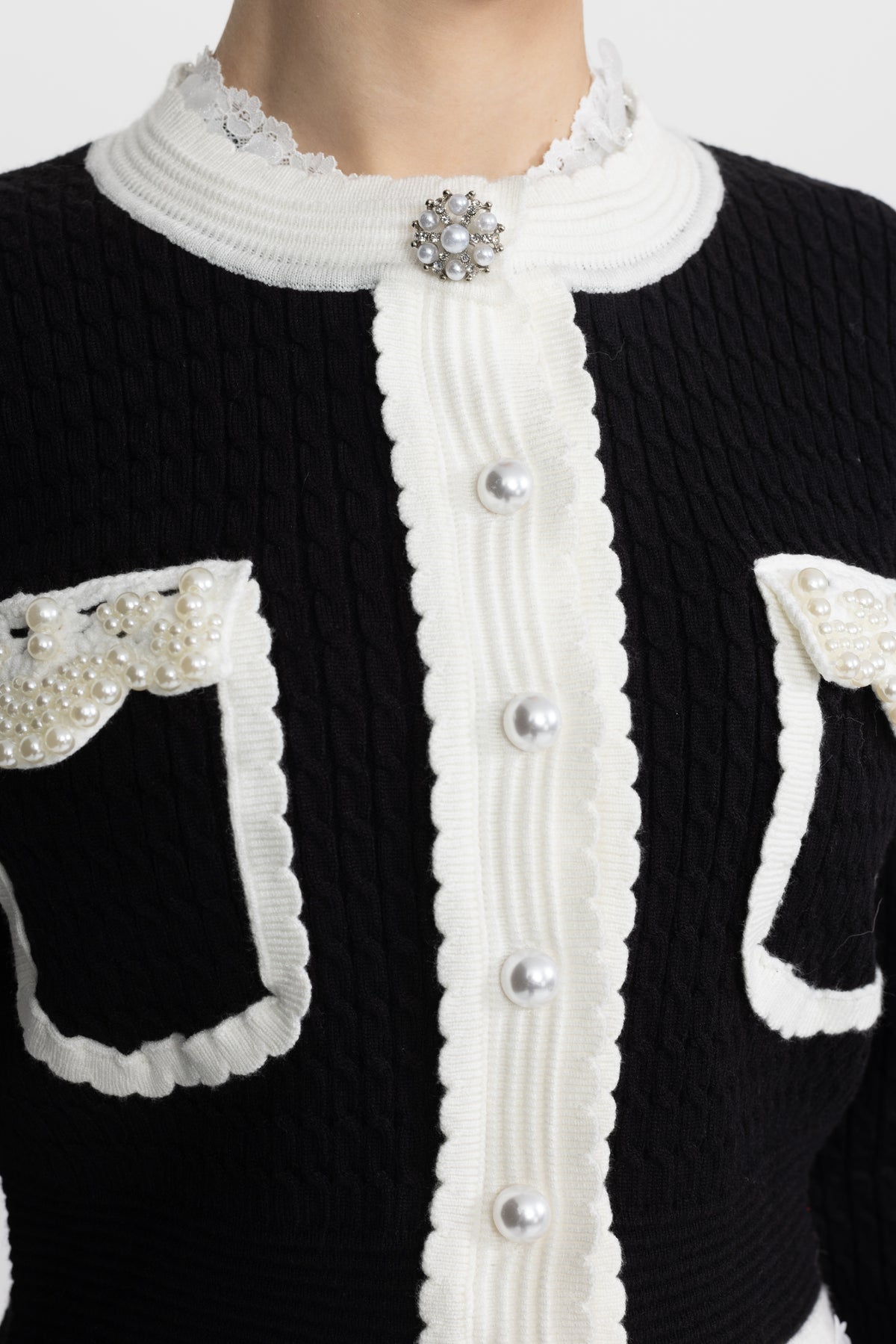 Kurze Cable-Strickjacke mit Perlenbesatz und Kontrastkante - Schwarz 